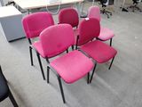 quatre chaises roses alignées dans un bureau