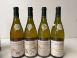 four bottles of wine are lined up on a table