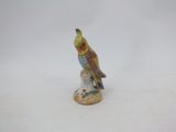 porcelain figurine of a bird perched on a tree stump