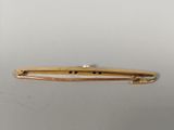 an image of a gold plated hair clip on a white surface
