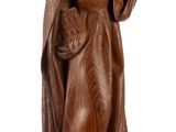 an old wooden statue of a woman holding a basket