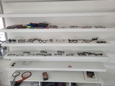 many pairs of glasses on the shelves in the room