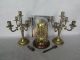 three brass candelabs with a glass dome on top of them