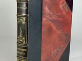 a black and red book sitting on top of a white table