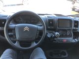 a man sitting in the driver ' s seat of a truck