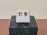 a pair of earrings sitting on top of a marble block