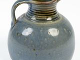 a blue vase with a handle on a white background