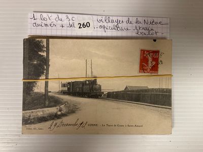 une photo d'un train sur les rails, avec une carte postale accrochée dessus