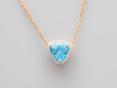 un pendentif en forme de cœur, composé d'une topaze bleue et de diamants, monté sur une chaîne en or