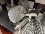 une photo d'une trancheuse à viande professionnelle posée sur un plan de travail