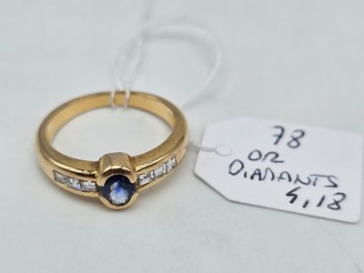 une image représentant une bague en or sertie d'un saphir et de diamants