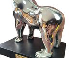 statue of a silver gorilla on a black base with a gold plaque around it