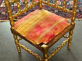 une chaise en bois sur laquelle est posé un coussin rouge