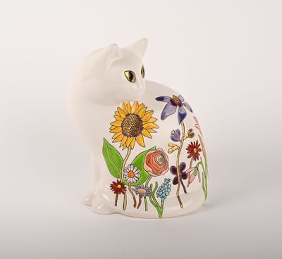 une figurine de chat blanc ornée d'un motif de tournesol