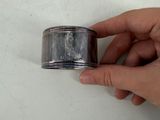 a hand that is holding a silver object on a table