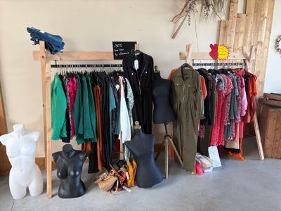 a display of clothes on a wooden rack in a room