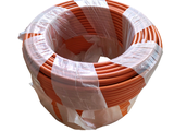 une bobine de fil orange et blanc recouverte de plastique