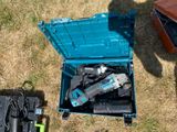 a blue tool box with tools in it sitting on the grass