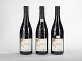 trois bouteilles de vin posées sur une surface blanche