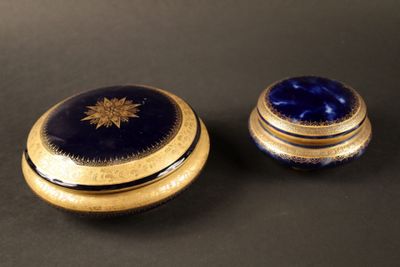 deux boîtes bleues et dorées posées sur une surface noire