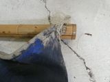 un parapluie bleu posé par terre à côté d'une canne de bambou