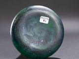 a green glass object with a sticker on it