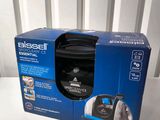 the box is open on a white table with a black cordless vacuum