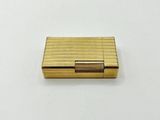 a close up of a gold cigarette case on a white surface