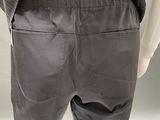 the back view of a mannequin wearing a black shirt and grey pants