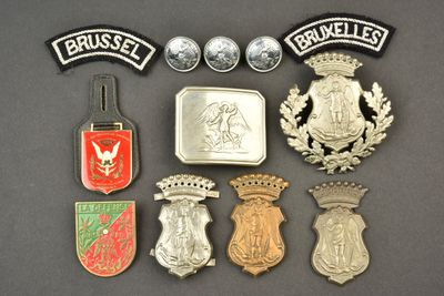 Plusieurs insignes différents sont disposés sur une surface noire
