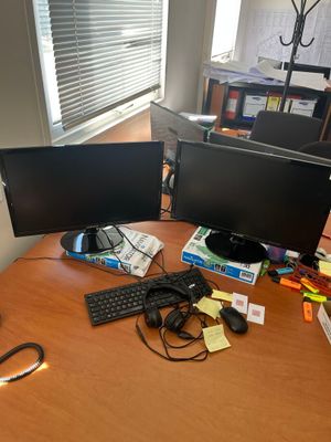 un bureau sur lequel sont posés deux écrans d'ordinateur et un clavier