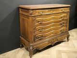 a wooden chest of drawers on a parquet floor