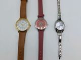 three different watches sitting next to each other on a white surface