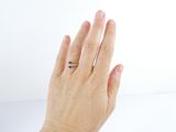 a woman ' s hand with a ring on it