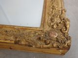 a gold frame with a mirror in it on the floor