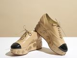 beige leather shoes with black soles on a white surface