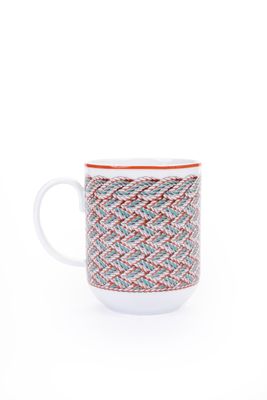 une tasse blanche ornée d'un motif rouge et bleu