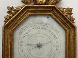 une vieille horloge avec un cadre doré et un cadran posée sur une table en bois