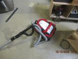 a red and black vacuum on the floor in a room