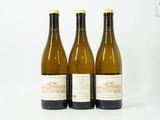 trois bouteilles de vin posées les unes à côté des autres sur une surface blanche