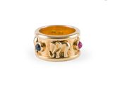 un gros plan sur une bague en or ornée d'éléphants et de pierres précieuses