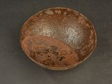 a rusted bowl sitting on a black surface