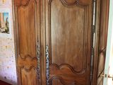 une grande armoire en bois dans le coin d'une pièce