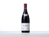 a bottle of red wine sitting on top of a white table