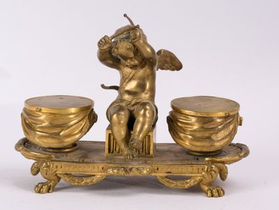 a gold statue of a cupid holding two cups on a tray