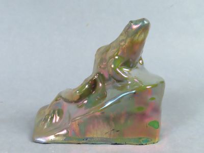 une figurine représentant une grenouille assise sur une chaussure