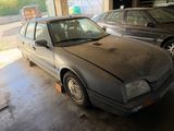 a dirty car in a garage with other cars in the background