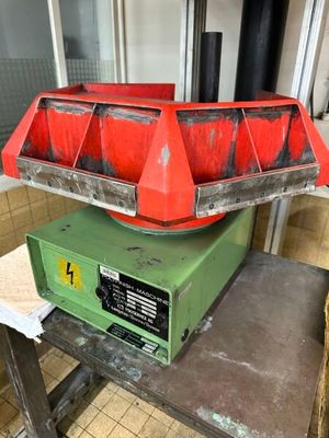une poubelle rouge posée sur une table en métal