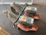 two chainsaws sitting on the floor next to a pair of shoes