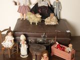 un tas de poupées posées sur une valise